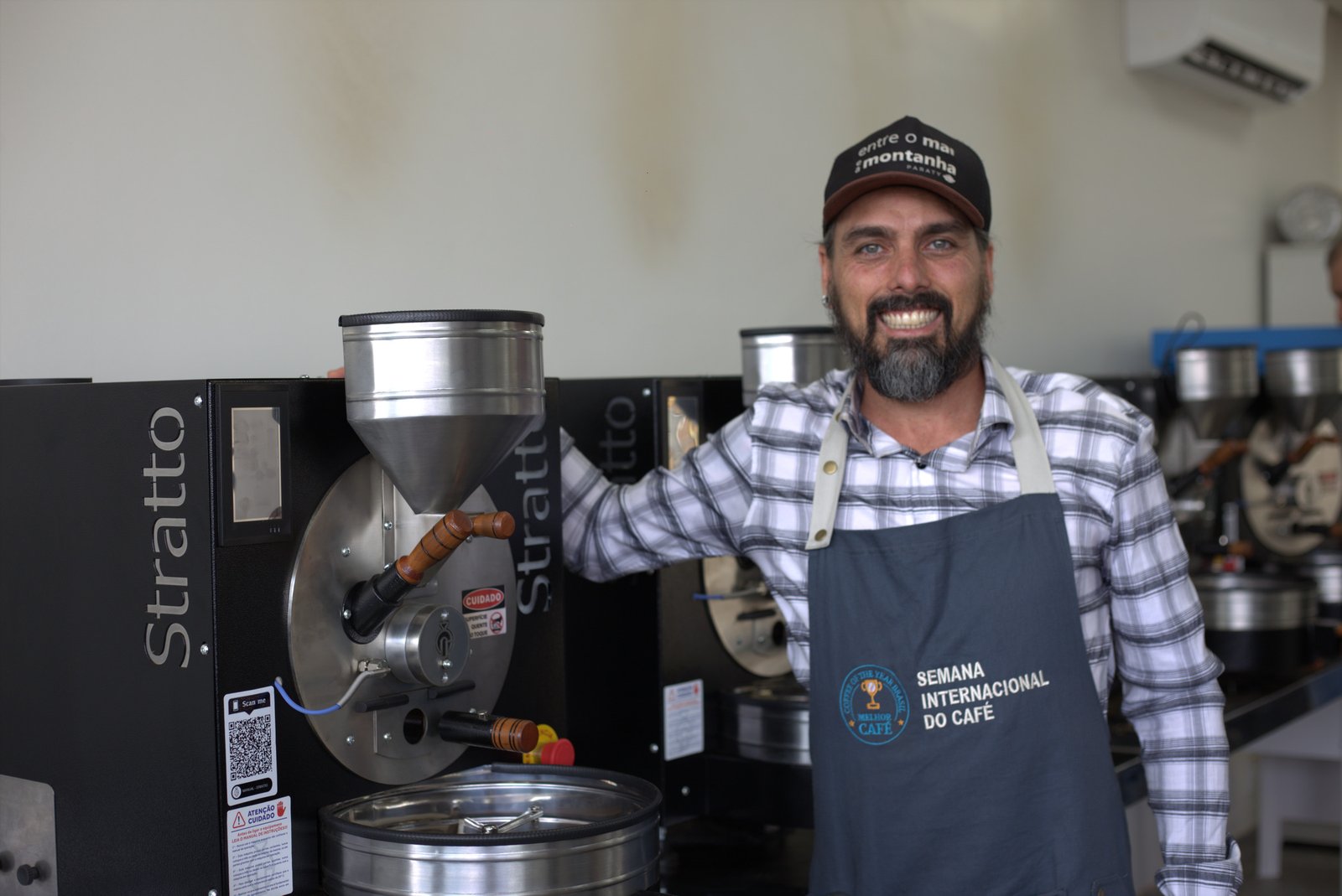 Matheus Levi ao lado de um torrador de café profissional